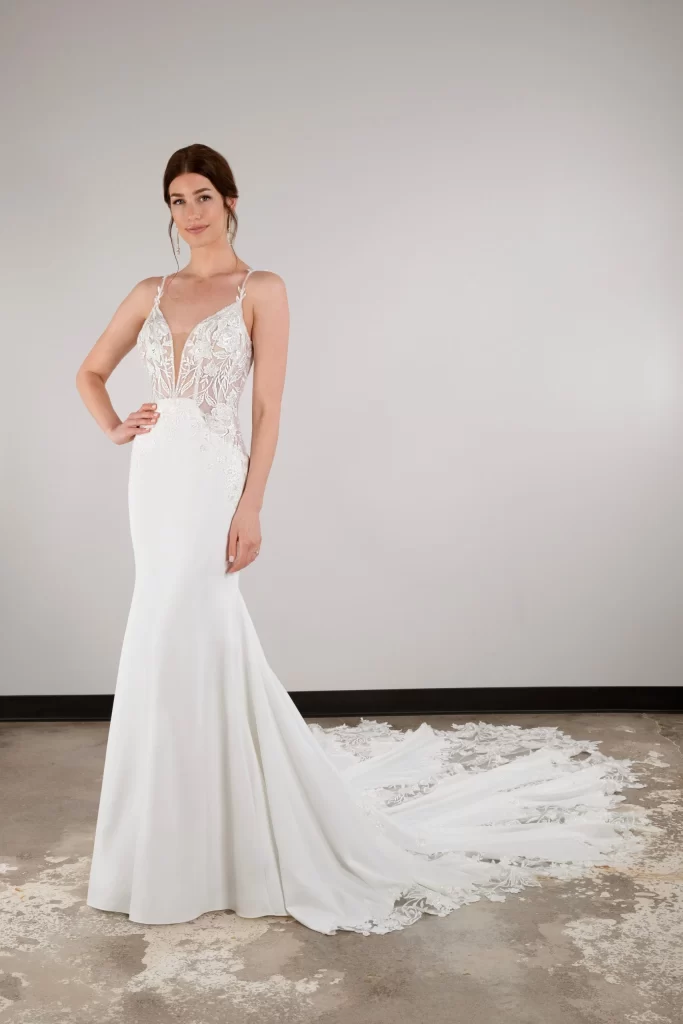 D3930-Essense of Australia-PureBridal, Edmonton bridal shop, Edmonton wedding dress, fit-and-flare wedding dress combines classic romance with sexy modern features to create a truly one-of-a-kind bridal look. Style D3930 features elegant beaded spaghetti straps that sparkle across the shoulder to connect to a floral lace bodice and deep plunging V-neckline. Sheer side cutouts frame the figure as intricately placed floral lace motifs sculpt the fitted silhouette. An open scooped back detail meets a subtle row of fabric-covered buttons as the gown transitions into a flowy crepe skirt adorned with delicate lace that concludes in a breathtaking long cut out train.