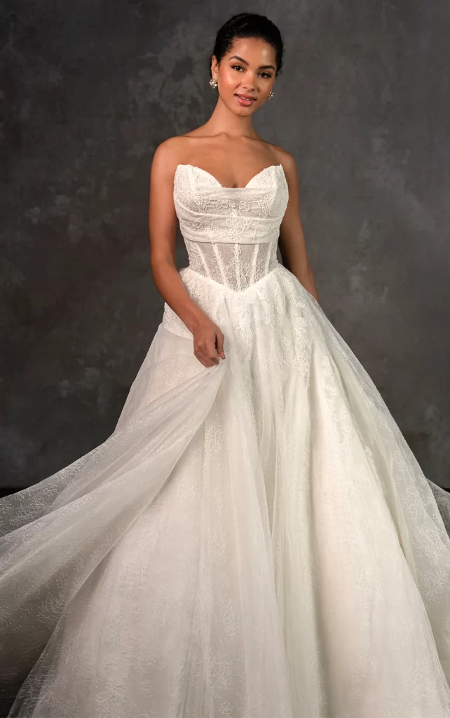 D4270-Essense of Australia-Pure Bridal. Edmonton bridal shop, Edmonton wedding dress. Airy romance meets contemporary elegance in Style D4270, a fashion-forward wedding gown that reimagines classic lace with a modern twist. The strapless sweetheart neckline exudes effortless beauty, while delicate Chantilly lace drapes over the sheer corset bodice for a touch of ethereal charm. From the structured Basque waist, the A-line silhouette unfolds into a soft, lace-adorned skirt that floats with weightless grace. A blend of sleek simplicity and dreamy detail, this gown is designed for the modern bride with a love for timeless romance. Also available in plus sizes.