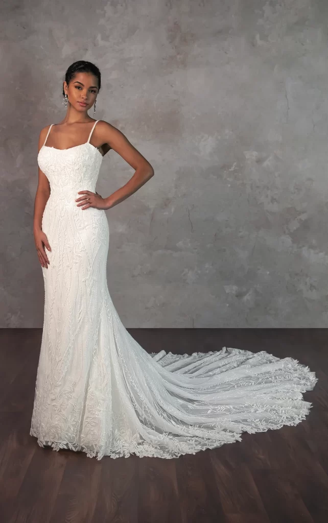 D4279-Essense of Australia-Pure Bridal, Edmonton wedding dress, Edmonton bridal shop. Radiating botanical elegance, Style D4279 is a shimmering lace masterpiece designed for the modern romantic. Sleek beaded spaghetti straps frame a delicate scoop neckline, leading to a bodice adorned with intricate 3D vine and lace appliques. The allover lace design cascades seamlessly into a fitted silhouette, flaring just above the knee for a graceful, ethereal effect. Finished with a breathtaking sheer lace train, this gown is perfect for the bride who embraces both natural beauty and contemporary sophistication. This wedding gown is also available in plus sizes.